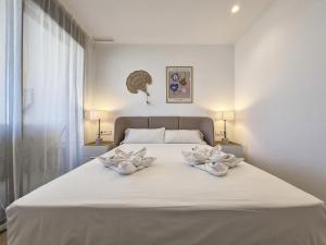 sypialnia z białym łóżkiem z dwoma białymi łukami w obiekcie Santa Rosalia Lake & Life Resort - 1410 w mieście Torre-Pacheco