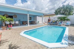 a swimming pool in front of a house at NEW ! Cozy Casa in Oranjestad