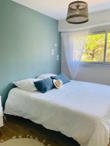 - une chambre avec un grand lit blanc et une fenêtre dans l'établissement Appartement résidence Les Faunes à La Baule, à La Baule