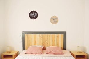 a bedroom with a bed with two pink pillows at Villa de la plage des Amiets #piscine intérieure privée# les pieds dans l'eau in Cléder +19 photos
