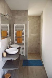 a bathroom with two sinks and a walk in shower at Villa de la plage des Amiets #piscine intérieure privée# les pieds dans l'eau in Cléder