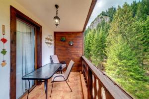 a balcony with a table and chairs and a large window at Luxury Flat in Grand Resort Pamporovo in Pamporovo