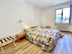 1 dormitorio con 1 cama y suelo de madera en Casa del Tempo Rosa Tassullo OSPITAR, en Tassullo