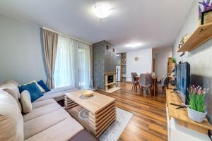 a living room with a couch and a table at Luxury Flat in Grand Resort Pamporovo in Pamporovo