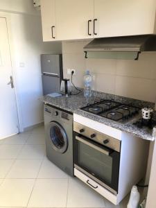 a kitchen with a stove and a washing machine at Casa Verde Women Only in Casablanca