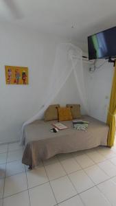 a bed in a white room with a tv at Logisrev in Sainte-Anne