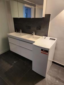 a white bathroom with two sinks and a mirror at Neumühler Hof Ferienwohnung "Stefan" bietet 4 Schlafzimmer und 4 Bäder , eine Große Badewanne und großer Terrasse zum Garten, kostenfreie Parkmöglichkeiten in Schwerin +59 photos