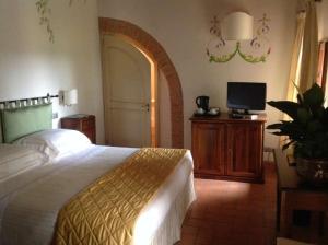 a bedroom with a bed and a flat screen tv at Villa Curina Resort in Castelnuovo Berardenga