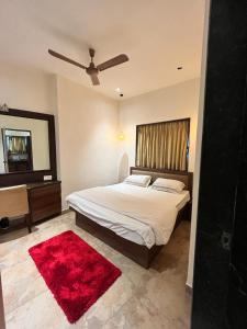 a bedroom with a bed and a red rug at Villa by the Sea in Mumbai