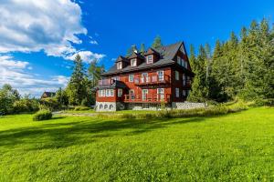 布科維納塔特贊斯卡的住宿－Bukowina Tatrzańska- apartament Dudek z widokiem na Tatry，绿地中树木繁茂的大房子