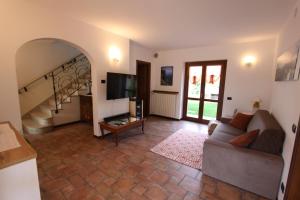 een woonkamer met een bank en een televisie bij Casa Nicole in Manerba del Garda