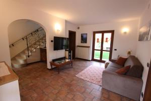 salon z kanapą i telewizorem w obiekcie Casa Nicole w Manerba del Garda