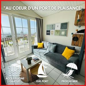 een woonkamer met een bank en een tafel bij "FENÊTRE SUR MER" Appartement vue mer, 4 personnes, accès parc aquatique in Saint-Jean-dʼOrbetiers