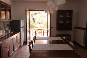 une cuisine avec des tables et des chaises ainsi qu'une grande fenêtre dans l'établissement Casa Nicole, à Manerba del Garda