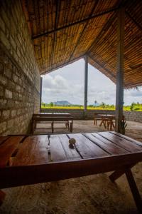 una stanza con tavoli e panche in legno in un edificio di Evergreen Hotel Dambulla a Dambulla