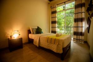 a bedroom with a bed and a large window at Evergreen Hotel Dambulla in Dambulla