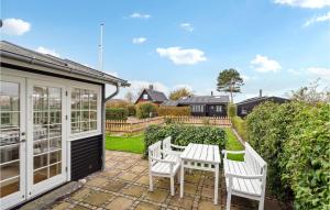 a patio with two white chairs and a table at Gorgeous Home In Assens With Kitchen in Assens