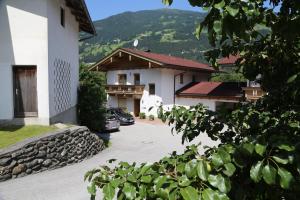 eine Gruppe von Gebäuden mit Autos, die in einer Einfahrt geparkt sind in der Unterkunft Haus Peter Schiestl in Zell am Ziller