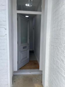 een hal met een witte deur en een witte muur bij Stylish 1 Bed Flat with Private Terrace in Wimbledon - 3 The Queens in Londen