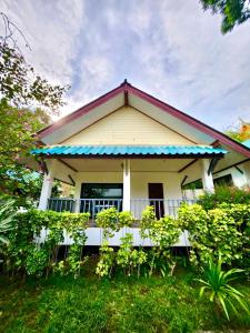 a small yellow house with a balcony at Three Trees Samui Resort - Sarocha Villa in Lamai