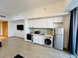 a kitchen with a washing machine and a washer at Furnished & Serviced Studio in Abu Dhabi