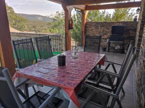 Casa rural La Gata في كامبيلو دي راناس: طاولة حمراء وكراسي على الفناء