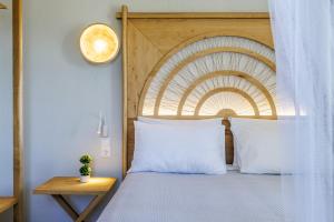 a bedroom with a bed with a wooden headboard at Villa Nektaria in Alikias