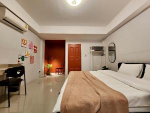 a bedroom with a large bed and a desk in it at 4 bedrooms, Private & Cozy house @ Walking Street in Chiang Rai