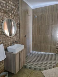 y baño con lavabo y espejo. en Arnhem Cave Lodge, en Omitara