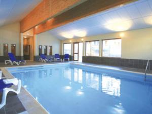a large swimming pool with blue chairs in a building at Studio Valloire, 1 pièce, 4 personnes - FR-1-263-527 in Valloire