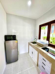 a kitchen with a sink and a refrigerator at Three Trees Samui Resort - Sarocha Villa in Lamai