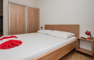 a bedroom with a white bed with a red blanket on it at Gorgeous Apartment In Drvenik With Kitchen in Donji Varoš
