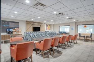 uma sala de espera com mesas e cadeiras num restaurante em Holiday Inn Express Hotel & Suites Columbus Airport, an IHG Hotel em Gahanna