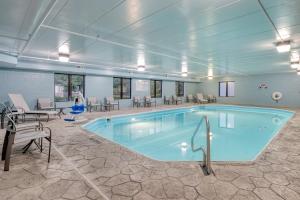 a large pool in a room with tables and chairs at Holiday Inn Express Hotel & Suites Columbus Airport by IHG in Gahanna