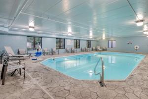 uma grande piscina numa sala com mesas e cadeiras em Holiday Inn Express Hotel & Suites Columbus Airport, an IHG Hotel em Gahanna