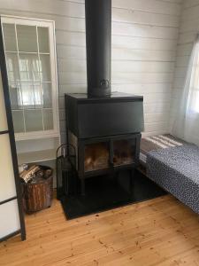 - une cheminée dans une chambre avec un lit et une fenêtre dans l'établissement A cosy cottage in Norrtälje, à Norrtälje