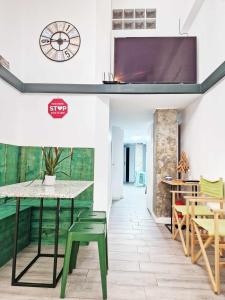 una sala da pranzo con tavolo, sedie e orologio di Alojamiento Simón 3 a Murcia