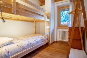 een slaapkamer met 2 stapelbedden en een raam bij Condominio Lucia 12 in Pinzolo