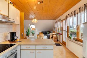 a kitchen with white cabinets and a living room at Haus Felix in Neubulach