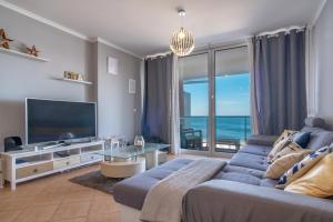 Apartment 7 on Paul do Mar Beach في بول دو مار: غرفة معيشة مع أريكة وتلفزيون بشاشة مسطحة