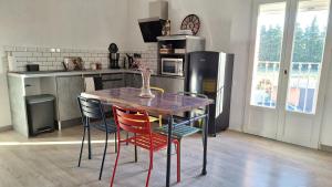 a kitchen with a wooden table with chairs and a refrigerator at Loft en duplex au Mas de la Restanque in Monteux