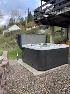 a hot tub sitting on the ground in a yard at Le chalet du cœur in Mittlach