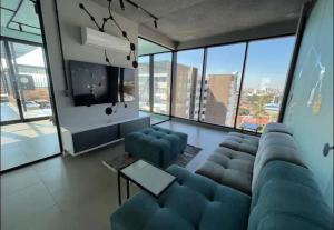sala de estar con sofá azul y TV en Comodo y lujos monoambiente Equipetrol NanoTec, en Santa Cruz de la Sierra