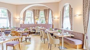 a restaurant with tables and chairs and windows at La Pura Women's Health Resort Kamptal in Gars am Kamp