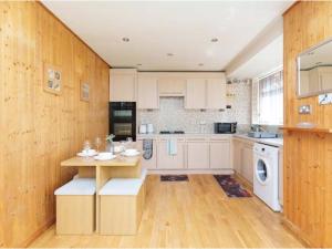 a kitchen with white cabinets and a table in it at Alexander House Apartments in Leeds