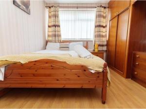 a bedroom with a wooden bed with a window at Alexander House Apartments in Leeds
