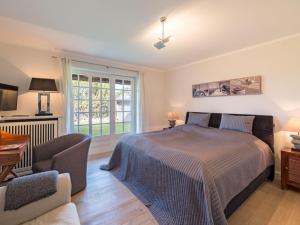 een slaapkamer met een bed, een stoel en een raam bij Leuchtturmblick-Sued in Kampen