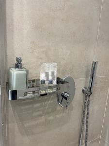 a bathroom with a soap dispenser on a wall at La Suite in Villa in Cittanova