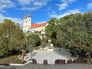 un grand bâtiment avec une tour d'horloge et des chaises dans un parc dans l'établissement Piros Vendégház, à Tihany