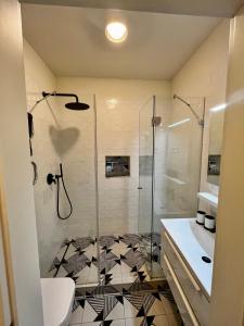 a bathroom with a shower and a black and white tile floor at A96 in Budapest